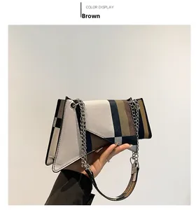 Detailed close-up of a color-block patchwork handbag with silver chain and leather strap
