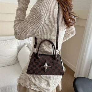 Classic checkered brown tote bag with star buckle shown held by a model in casual wear