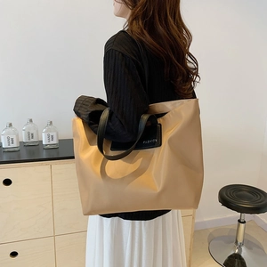 Large khaki nylon tote bag with black leather handles and fashion logo for commuting