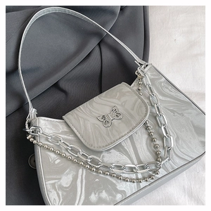 Detail view of marble pattern underarm bag with silver chain and butterfly charm decoration