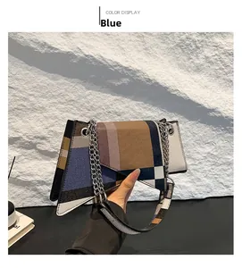 Detail view of geometric patchwork shoulder bag in blue, brown, and grey with silver chain