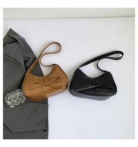 Detail von Hobo-Taschen in Schwarz und Braun mit Schleifendekor und Falten