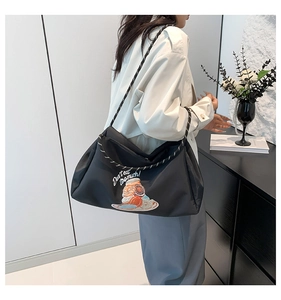 Détail d'un sac cabas en nylon noir avec imprimés donuts et anses en corde