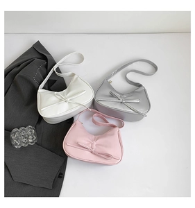 Schicke Achseltaschen mit Schleife in Weiß, Silber und Rosa in stilvoller Anordnung