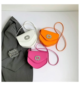 Détails de trois mini sacs bandoulière en blanc, orange et rose avec boucles en strass
