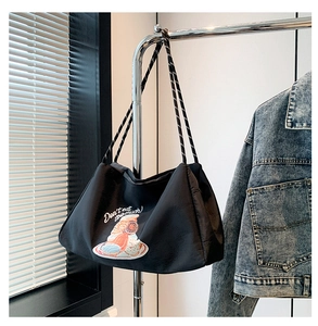 Détail du sac cabas noir avec imprimé donut et poignées rayées bicolores