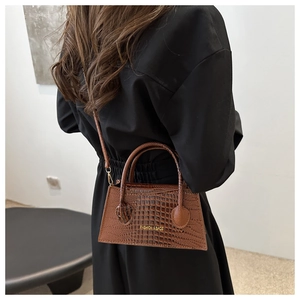Close-up of brown crocodile texture leather bag with Fashion & Bags text on crossbody strap