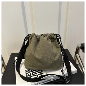 Dettaglio della borsa a secchiello in nylon verde oliva con coulisse ed etichetta moda