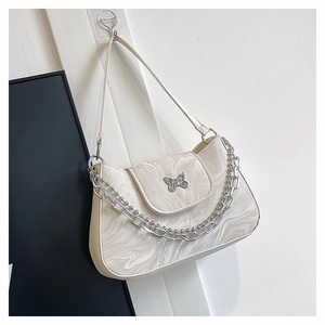 Detail of beige marble pattern shoulder bag with silver butterfly clasp and metal chain