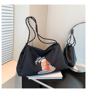 Détail du sac cabas noir avec broderie de donut et bandoulières en corde tressée