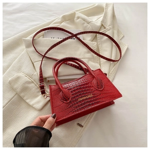 Close-up of red crocodile pattern leather texture with golden Fashion & Bags text logo