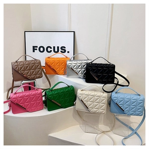 Macro detail of quilted PU leather mini bags with gold metal bars and crossbody straps