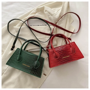 Detail showing crocodile texture on red and green tote bags with gold hardware accents