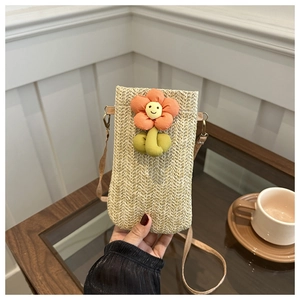 Detailed shot of a hand-woven phone bag featuring a plush 3D sunflower and long shoulder strap