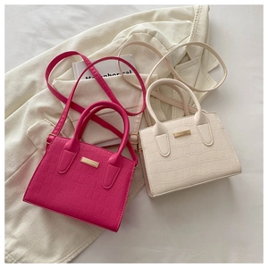 Détail de mini sacs à main motif crocodile en rouge rose et beige à garniture dorée