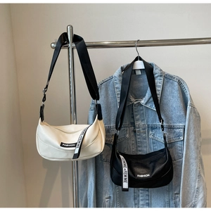 Close-up of crescent moon bags in white and black with wide stylish fabric shoulder straps