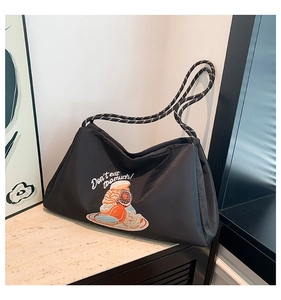 Détail d'un sac bandoulière noir matelassé avec broderie donut et anse en corde