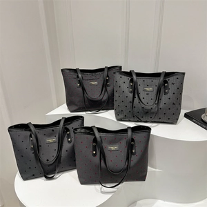 Chic dark gray canvas tote bags with heart and polka dot patterns on a white stand