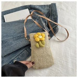 Close-up of woven straw phone bag featuring a yellow sunflower and gold strap hook