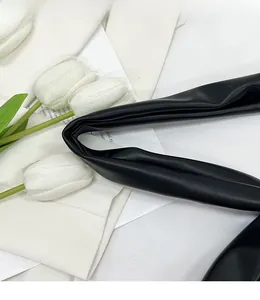 Nahaufnahme des breiten schwarzen Leder-Schultergurts an einer minimalistischen Tasche