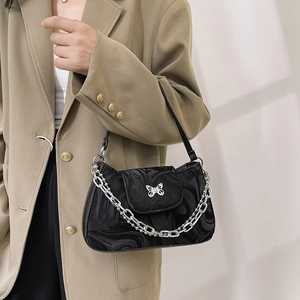 Elegant black underarm bag with marble texture and silver butterfly buckle on model