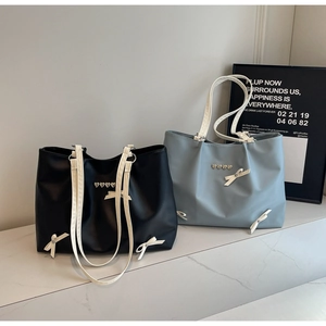 Detailed view of tote bags with heart metal studs and white ribbon bow accents
