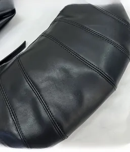 Detailaufnahme von schwarzem Leder und horizontalen Nähten einer schlichten Tasche