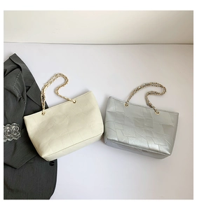 Detail of minimalist tote bags with geometric texture and golden chain straps