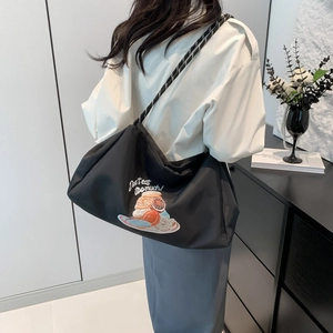 Grand sac cabas noir avec broderie de dessert et poignées en corde sur un mannequin