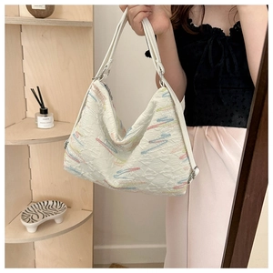 Détail du sac hobo blanc matelassé avec broderie de vagues colorées et anses en cuir