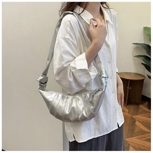 Details der silbernen Croissant-Tasche mit trendiger Faltenoptik und Knotendesign