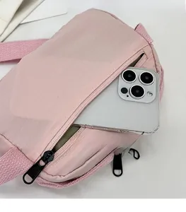Detail view of pink crossbody bag showing the transparent mesh pocket with a smartphone