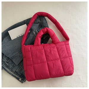 Détail macro du sac fourre-tout matelassé magenta avec coutures et texture rembourrée douce