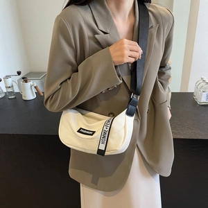 Minimalist cream crescent crossbody bag with black logo strap and lychee texture