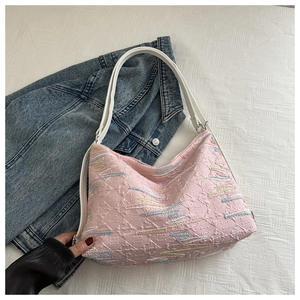 Détail d'un sac cabas rose brodé avec motifs géométriques et bandoulière blanche