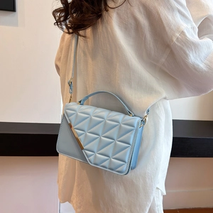 Quilted light blue crossbody bag with triangular texture and golden metal trim detail