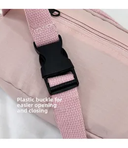 Close-up of durable black plastic buckle and pink nylon checkered fabric on shoulder bag