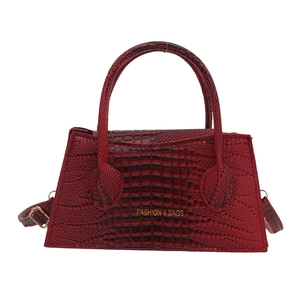 Red crocodile pattern trapezoid handbag with gold hardware and adjustable strap