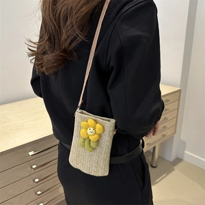Woven straw crossbody phone bag with yellow flower smile charm and pink shoulder strap
