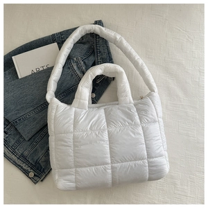 Gros plan du sac cabas matelassé blanc avec surpiqûres carrées et zip latéral