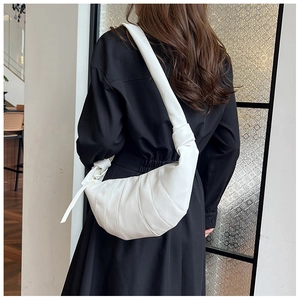 Rückansicht eines Models mit weißer Leder-Croissant-Tasche über schwarzem Kleid