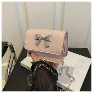 Détail du sac à bandoulière en cuir brillant rose clair avec boucle noeud en métal argenté