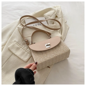 Close-up of beige woven crossbody bag with brown leather flap and metal lock on soft jacket