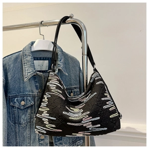 Vue détaillée du sac noir texturé avec broderie vagues colorées et bandoulière en cuir