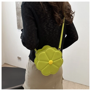 Model view of a bright green flower-shaped crossbody bag with a yellow center button