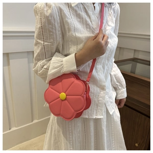 Detail view of pink floral crossbody bag with yellow center and slim shoulder strap
