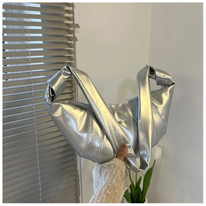 Details der silbernen Metallic-Beuteltasche mit Knotengriff und Faltenstruktur