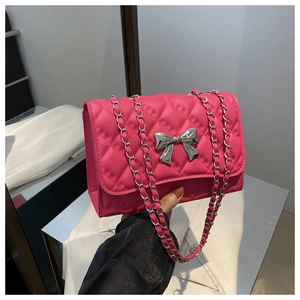Détail du sac à bandoulière matelassé rose avec nœud en argent et sangle de chaîne