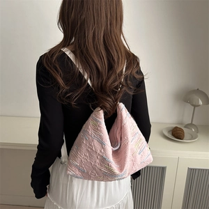 Grand sac cabas rose avec texture matelassée et broderie colorée porté par modèle