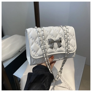 Détail du sac bandoulière blanc matelassé avec nœud argenté et bandoulière chaîne